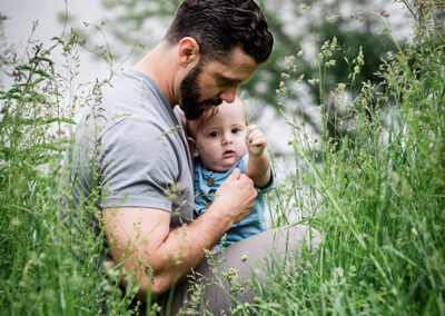 young boy and his dad sitting in the grass